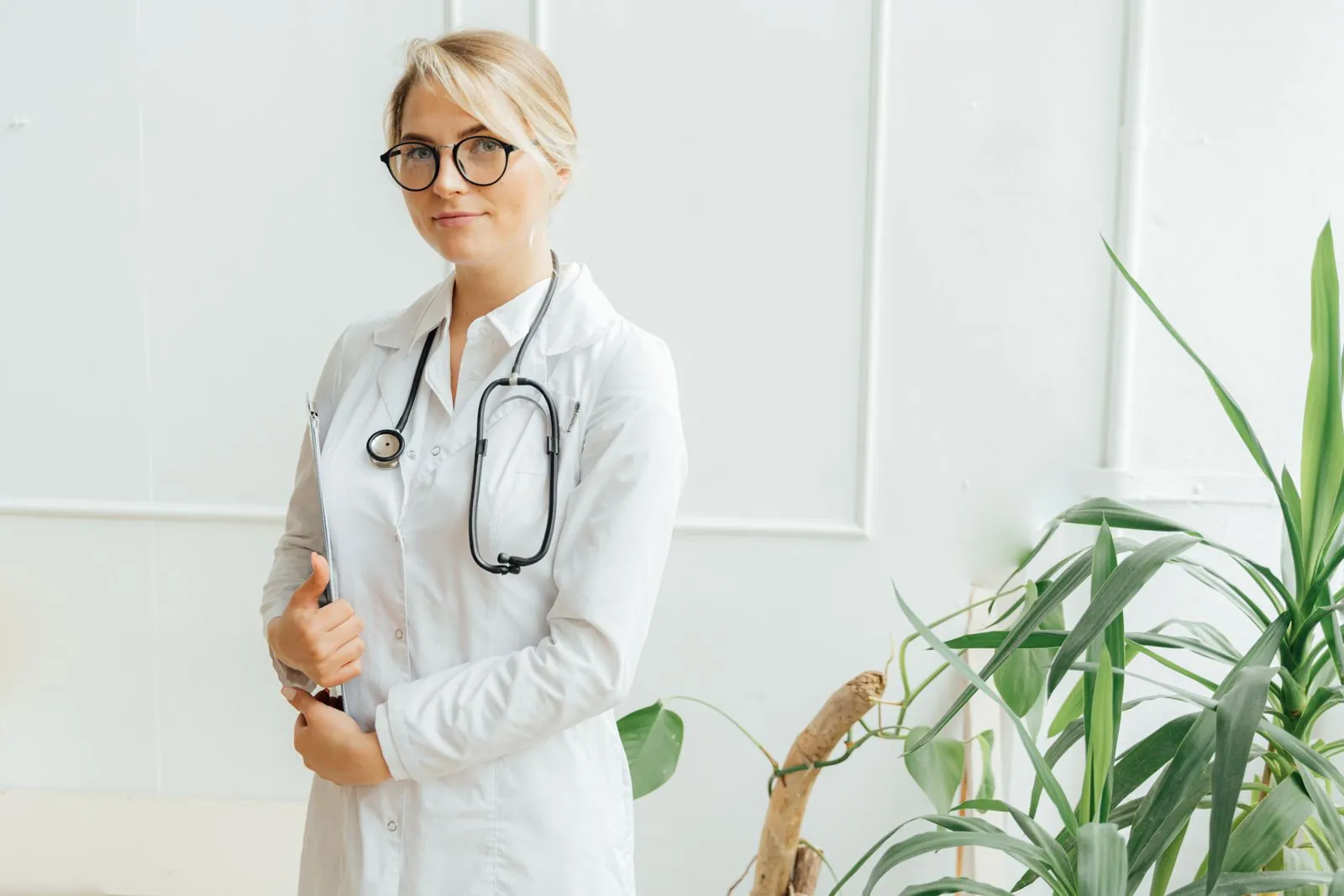 Healthcare clinician holding a clipboard in a bright clinical setting