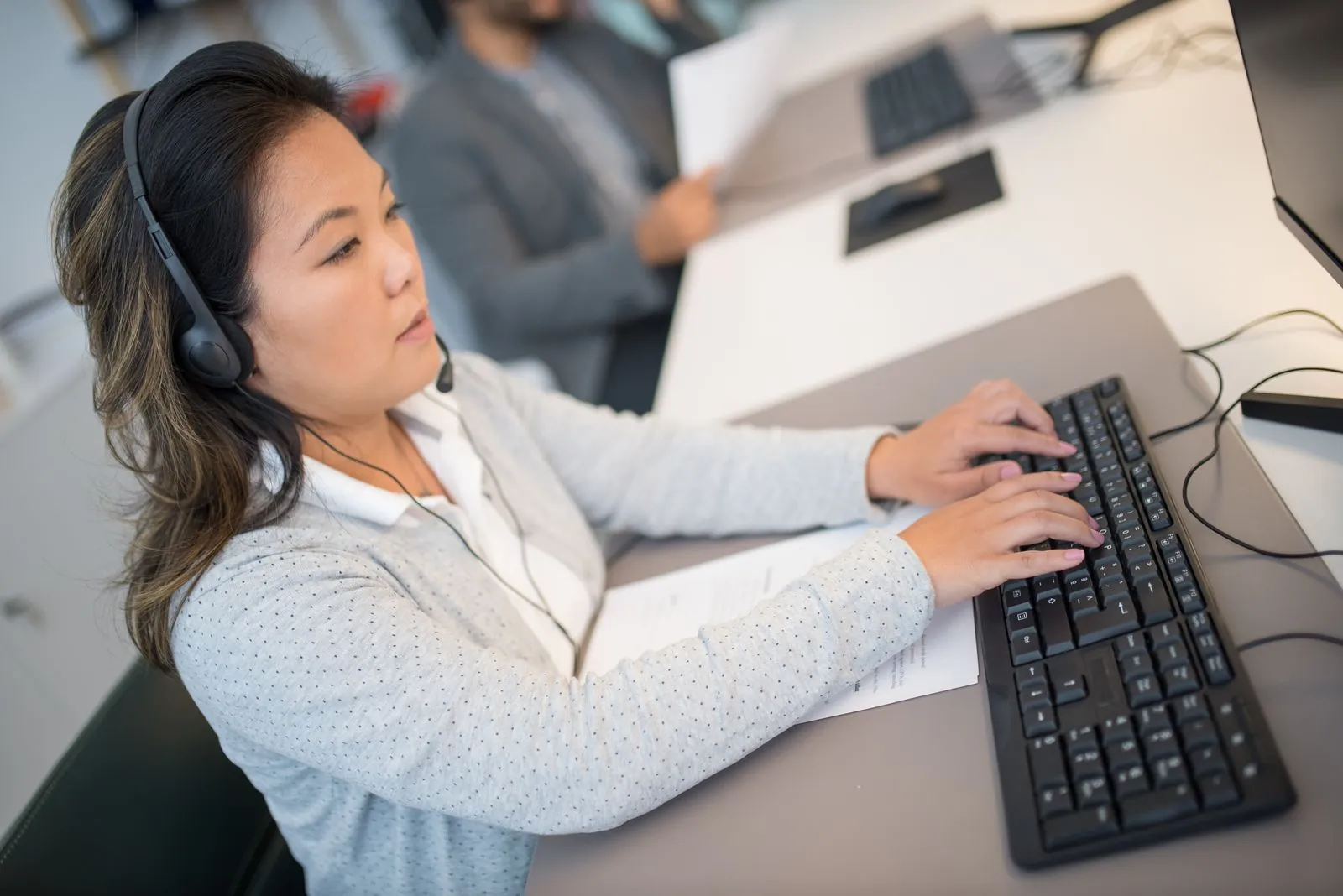 Contact-center agents at their workstations wearing headsets